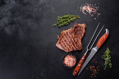 Lezzetli taze biftek, esrarlı baharatlar ve çimento kaplı otlar. Izgara yemek.