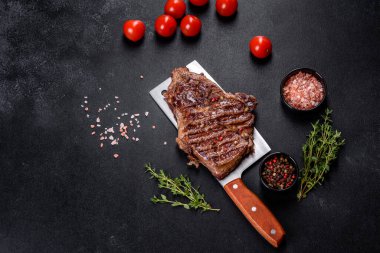 Lezzetli taze biftek, esrarlı baharatlar ve çimento kaplı otlar. Izgara yemek.