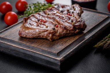 Lezzetli taze biftek, esrarlı baharatlar ve çimento kaplı otlar. Izgara yemek.