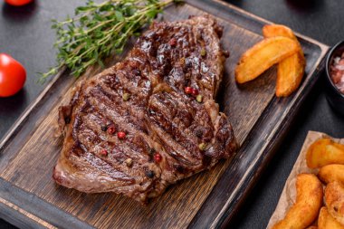 Lezzetli taze biftek, esrarlı baharatlar ve çimento kaplı otlar. Izgara yemek.