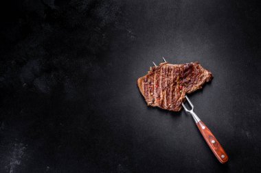 Lezzetli taze biftek, esrarlı baharatlar ve çimento kaplı otlar. Izgara yemek.