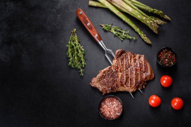 Lezzetli taze biftek, esrarlı baharatlar ve çimento kaplı otlar. Izgara yemek.