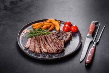 Lezzetli taze biftek, esrarlı baharatlar ve çimento kaplı otlar. Izgara yemek.