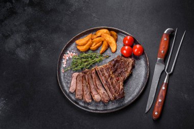 Lezzetli taze biftek, esrarlı baharatlar ve çimento kaplı otlar. Izgara yemek.