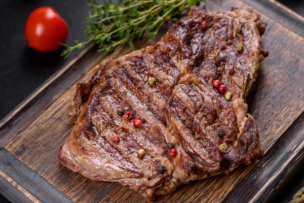 Deliziosa Bistecca Manzo Fresco Con Spezie Erbe Uno Sfondo Cemento — Foto Stock