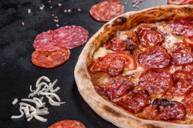 Pizza soslu Pepperoni pizza, mozzarella peyniri ve pepperoni. İçinde malzemeler olan bir masada pizza.