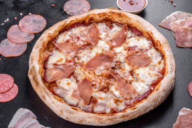 Koyu beton arka planda prosciutto ile taze, lezzetli İtalyan pizzası. İtalyan mutfağı
