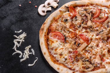 Koyu beton arka planda mantarlı ve domatesli taze İtalyan pizzası. İtalyan mutfağı