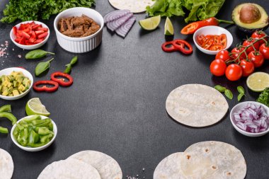 Biftek, domates, avokado, soğan ve salsa soslu Meksika tacoları.