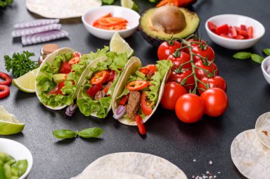 Biftek, domates, avokado, soğan ve salsa soslu Meksika tacoları.