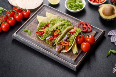 Biftek, domates, avokado, soğan ve salsa soslu Meksika tacoları.