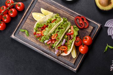 Biftek, domates, avokado, soğan ve salsa soslu Meksika tacoları.