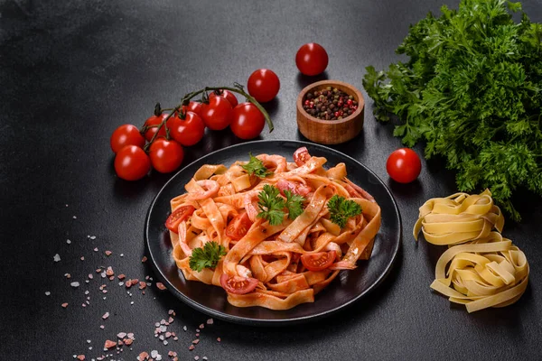 stock image Fettuccine pasta with shrimp, cherry tomatoes, sauce, spices and herbs. Mediterranean cuisine