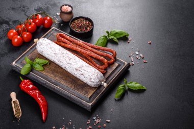 Koyu beton arka planda kurutulmuş İspanyol sosisi salamı. Lezzetli taze sandviçlerin hazırlığı