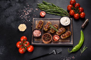 Izgara sosis ve arka planda bitki ve sebze. Izgara yemek, barbekü