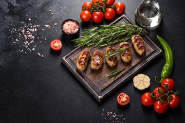 Izgara sosis ve arka planda bitki ve sebze. Izgara yemek, barbekü