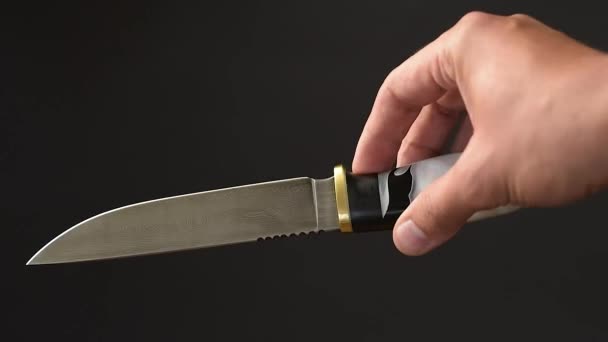 濃いコンクリートの背景に鋭い灰色の刃を持つ手作りの美しい狩猟ナイフ — ストック動画