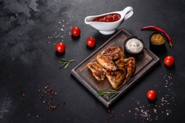 Baharat ve otlarla kaplanmış baharatlı tavuk kanatları. Ateşle pişirilmiş sağlıksız yemekler.