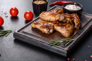 Baharat ve otlarla kaplanmış baharatlı tavuk kanatları. Ateşle pişirilmiş sağlıksız yemekler.