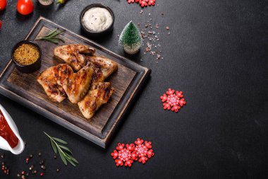 Baharat ve otlarla kaplanmış baharatlı tavuk kanatları. Ateşle pişirilmiş sağlıksız yemekler.