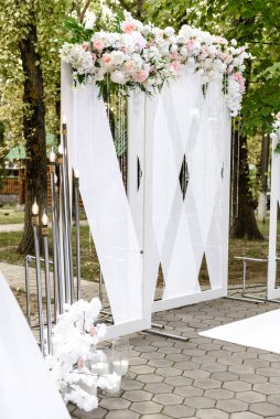 Düğün töreni için restoranda güzel çiçek kompozisyonları. Damat ve gelinin resmedildiği resmi tören