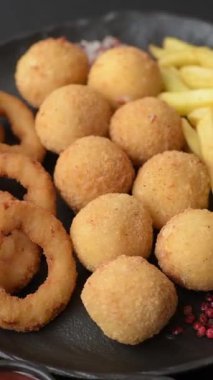 Fast food, peynir topları, soğan ya da kalamar halkaları ve patates kızartması. Tasarımınız için arka plan olarak abur cubur