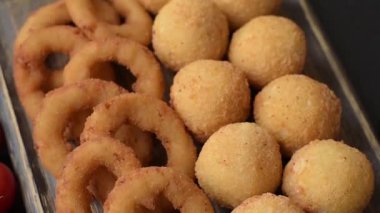 Fast food, peynir topları, soğan ya da kalamar halkaları ve patates kızartması. Tasarımınız için arka plan olarak abur cubur