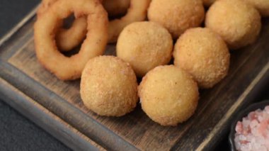 Fast food, peynir topları, soğan ya da kalamar halkaları ve patates kızartması. Tasarımınız için arka plan olarak abur cubur