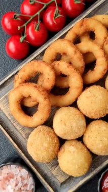 Fast food, peynir topları, soğan ya da kalamar halkaları ve patates kızartması. Tasarımınız için arka plan olarak abur cubur