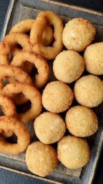 Fast food, peynir topları, soğan ya da kalamar halkaları ve patates kızartması. Tasarımınız için arka plan olarak abur cubur