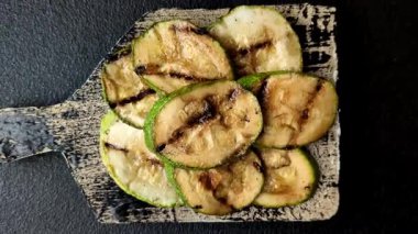 Izgara yeşil kabak dilimleri, vejetaryen yemekleri. Tasarımınız için yemek arkaplanı olarak yeşil barbekü kabağı