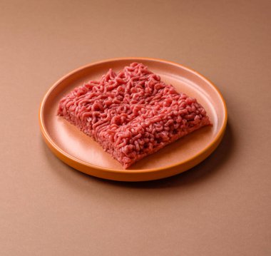 Raw ground beef for a burger or as an ingredient in a meat dish. Raw ground beef as a food background for your design