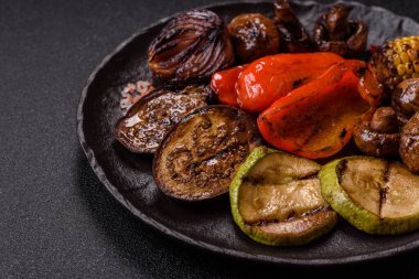 Izgara sebze, dolmalık biber, mantar ve kabak soslu sağlıklı vejetaryen yemeği. Tasarımın için yemek arkaplanı olarak bir tabakta ızgara sebze..