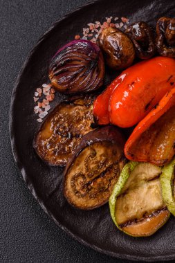 Izgara sebze, dolmalık biber, mantar ve kabak soslu sağlıklı vejetaryen yemeği. Tasarımın için yemek arkaplanı olarak bir tabakta ızgara sebze..