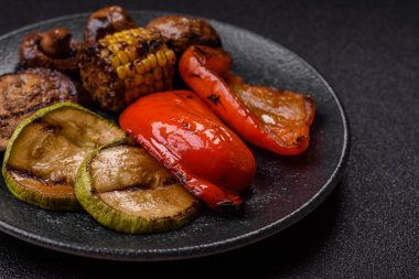 Izgara sebze, dolmalık biber, mantar ve kabak soslu sağlıklı vejetaryen yemeği. Tasarımın için yemek arkaplanı olarak bir tabakta ızgara sebze..