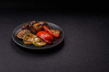 Izgara sebze, dolmalık biber, mantar ve kabak soslu sağlıklı vejetaryen yemeği. Tasarımın için yemek arkaplanı olarak bir tabakta ızgara sebze..