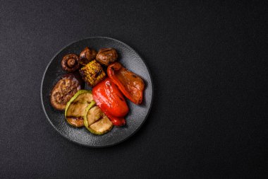 Izgara sebze, dolmalık biber, mantar ve kabak soslu sağlıklı vejetaryen yemeği. Tasarımın için yemek arkaplanı olarak bir tabakta ızgara sebze..