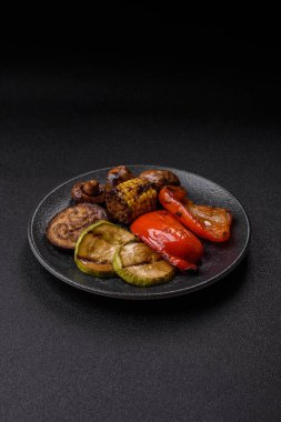 Izgara sebze, dolmalık biber, mantar ve kabak soslu sağlıklı vejetaryen yemeği. Tasarımın için yemek arkaplanı olarak bir tabakta ızgara sebze..