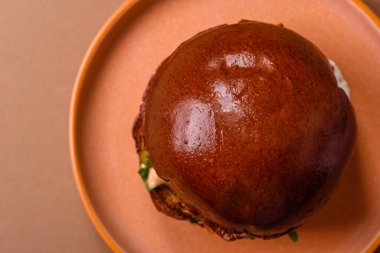 A burger, a hamburger with cheese, beef, and a bun, is unhealthy takeaway food. A burger or cheeseburger as a food background for your design.