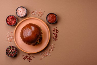 A burger, a hamburger with cheese, beef, and a bun, is unhealthy takeaway food. A burger or cheeseburger as a food background for your design.