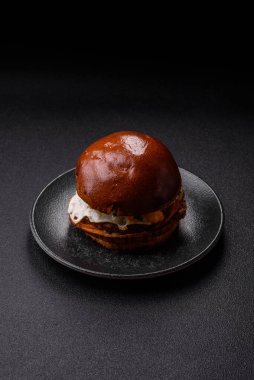 A burger, a hamburger with cheese, beef, and a bun, is unhealthy takeaway food. A burger or cheeseburger as a food background for your design.