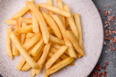 French fries are salty, crispy, and fried in oil, unhealthy takeaway food. French fries as a food backdrop for your design.