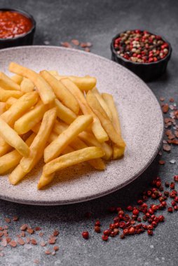 French fries are salty, crispy, and fried in oil, unhealthy takeaway food. French fries as a food backdrop for your design.