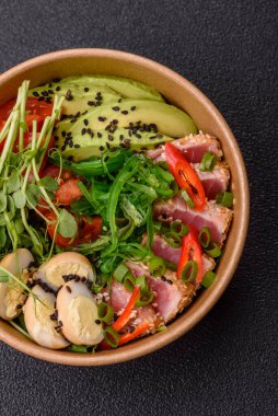 Susam tohumu, pirinç ve sebze dolu bir kasede kurutulmuş ton balığı. Tasarımınız için arkaplan olarak ton balığı tataki.