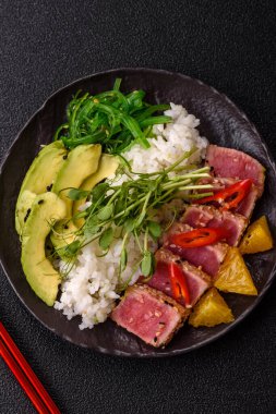 Susam tohumu, pirinç ve sebze dolu bir kasede kurutulmuş ton balığı. Tasarımınız için arkaplan olarak ton balığı tataki.