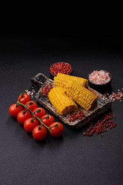 Mısır koçanı, sebzeler ve sağlıklı vejetaryen yemeklerle pişirilir. Tasarımınız için yemek arkaplanı olarak haşlanmış mısır