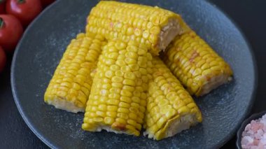 Mısır koçanı, sebzeler ve sağlıklı vejetaryen yemeklerle pişirilir. Arkaplan olarak haşlanmış mısır