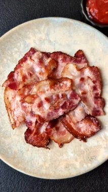 Sağlıklı bir kahvaltı için kızarmış domuz pastırması şeritleri. Tasarımınız için yiyecek olarak kızarmış pastırma şeritleri.