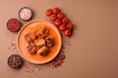 Domates sosunda haşlanmış balık, biberli güveç ve havuç. Tasarımınız için yemek arkaplanı olarak domates soslu haşlama balık..