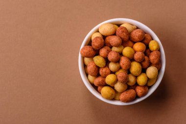 Yiyecek, tuz ve paprikayla kaplı fındık, protein kaynağı olarak da fıstık. Tasarımınız için yemek arkaplanı olarak kırmızı biberli tuzlu fıstık.